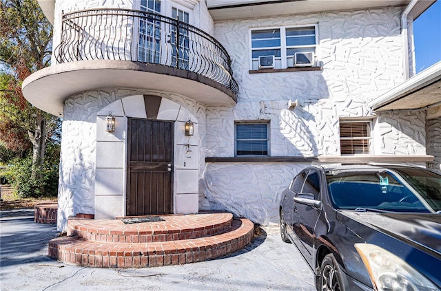 view of exterior entry featuring a balcony