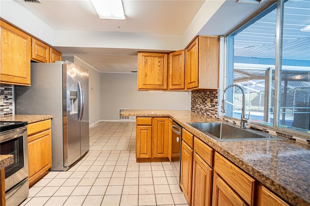 kitchen featuring light tile patterned flooring, sink, stainless steel appliances, and tasteful backsplash