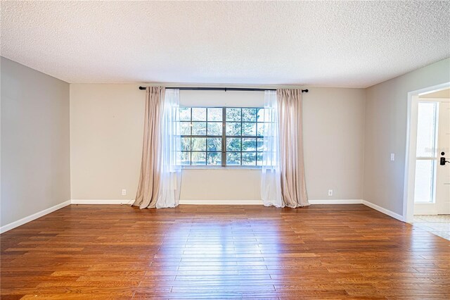 spare room with a textured ceiling and hardwood / wood-style flooring