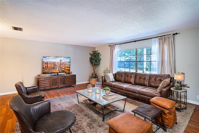 living room featuring wood-type flooring and a textured ceiling