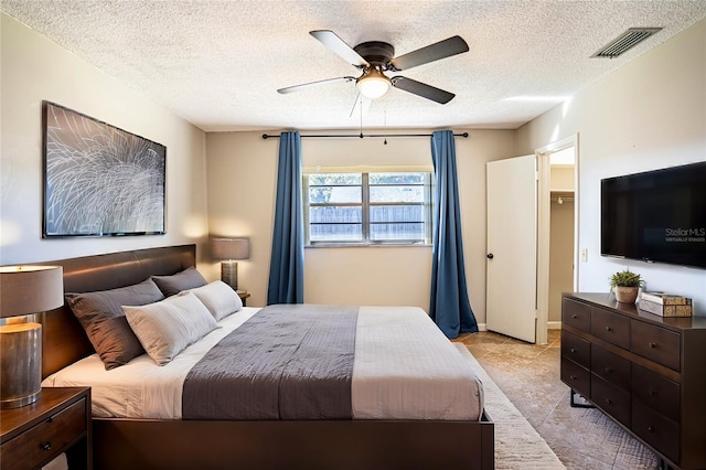 bedroom featuring ceiling fan and a textured ceiling