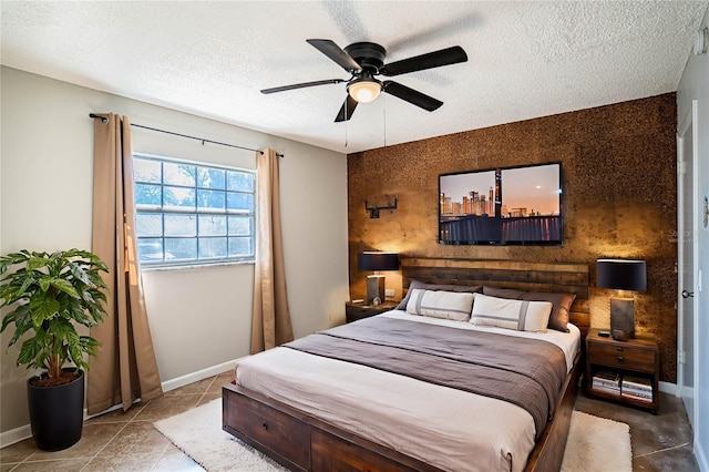 bedroom with tile patterned floors, ceiling fan, and a textured ceiling