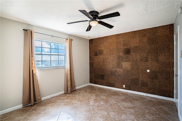 empty room featuring ceiling fan and a textured ceiling