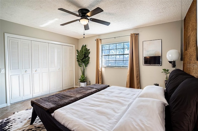 bedroom with tile patterned floors, ceiling fan, a textured ceiling, and a closet