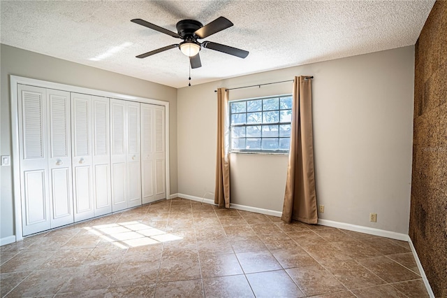 unfurnished bedroom featuring ceiling fan, a closet, and a textured ceiling