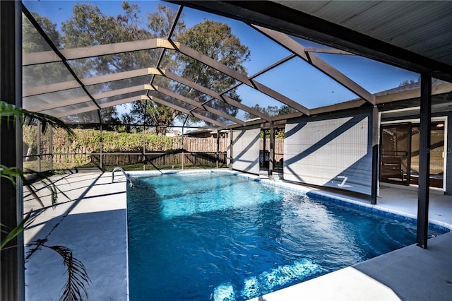 view of pool with glass enclosure and a patio