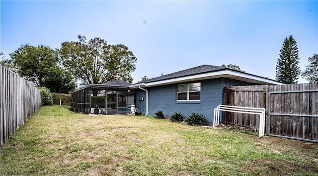 back of property with a lanai and a lawn