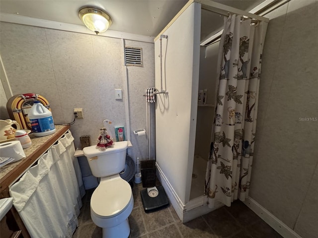 bathroom with toilet and a shower with shower curtain