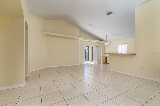 unfurnished room with light tile patterned flooring, an inviting chandelier, and vaulted ceiling