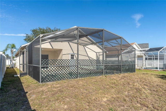 back of property featuring a yard, cooling unit, and a lanai