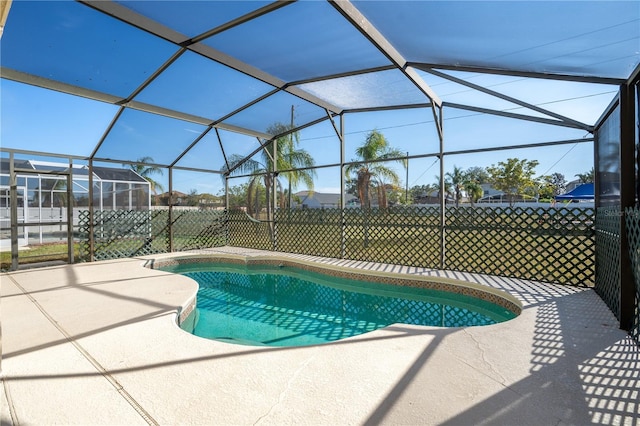 view of pool with glass enclosure and a patio