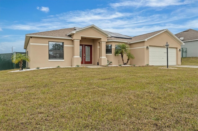 view of front facade with a garage, a front yard, and solar panels