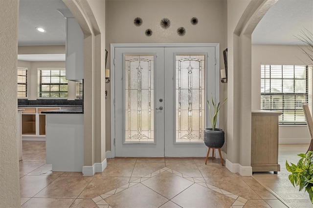 entrance foyer with light tile patterned floors and french doors