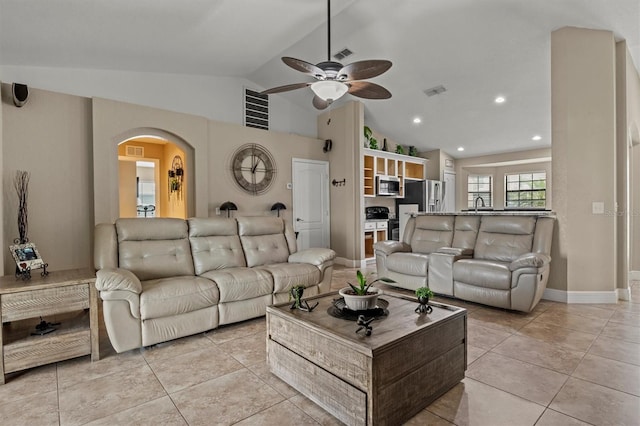 tiled living room with ceiling fan, lofted ceiling, and sink