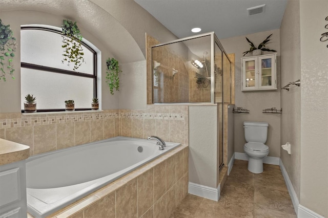 bathroom featuring shower with separate bathtub and toilet