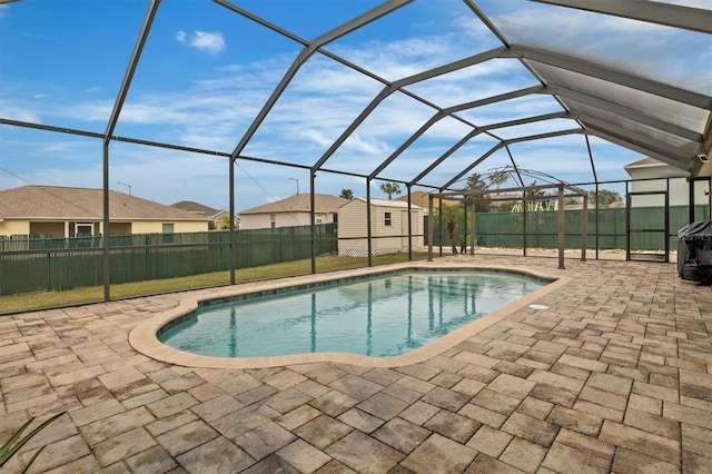 view of swimming pool with glass enclosure and a patio area