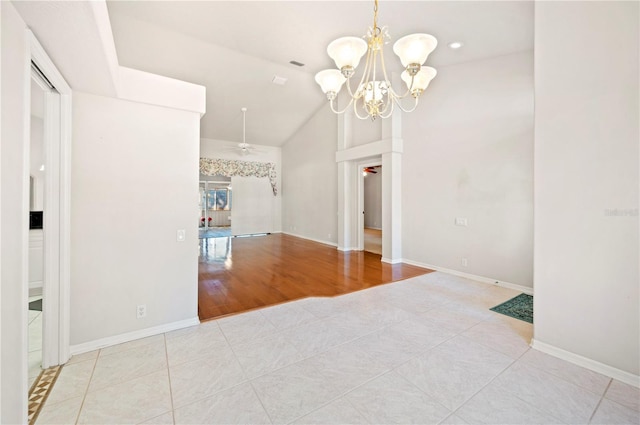 tiled spare room with lofted ceiling and an inviting chandelier