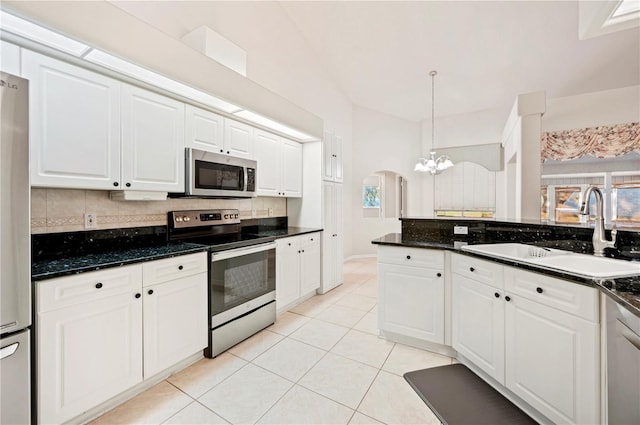 kitchen with white cabinetry, sink, stainless steel appliances, a notable chandelier, and pendant lighting