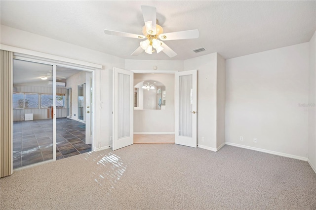 unfurnished bedroom with ceiling fan, french doors, and dark carpet