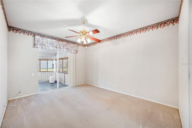 spare room featuring radiator heating unit, light colored carpet, and ceiling fan