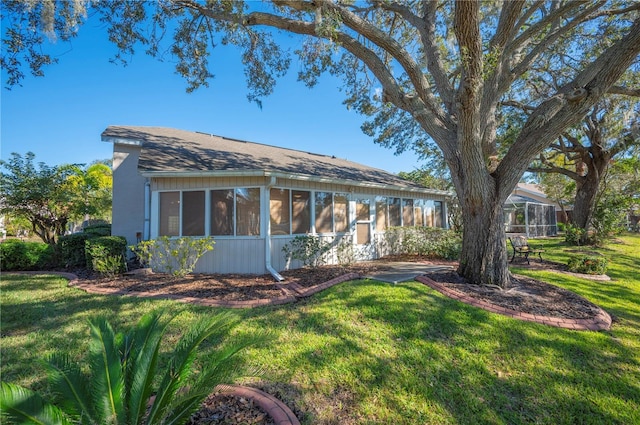 view of side of property with a sunroom and a yard