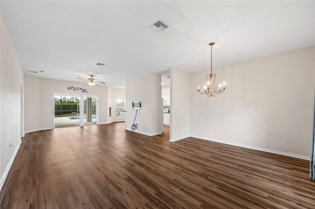 unfurnished living room with dark hardwood / wood-style flooring and ceiling fan with notable chandelier