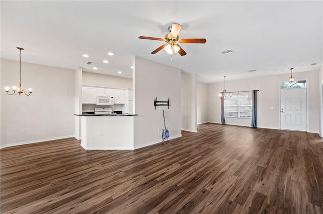 unfurnished living room featuring ceiling fan with notable chandelier and dark wood-type flooring