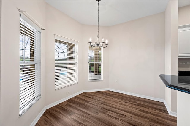 unfurnished dining area featuring dark hardwood / wood-style floors and a notable chandelier