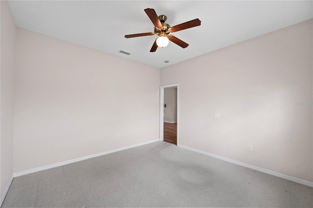 carpeted spare room with ceiling fan