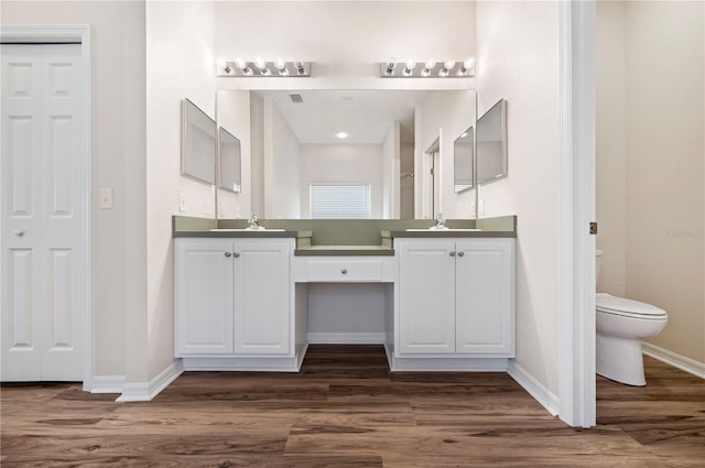 bathroom with hardwood / wood-style floors, vanity, and toilet