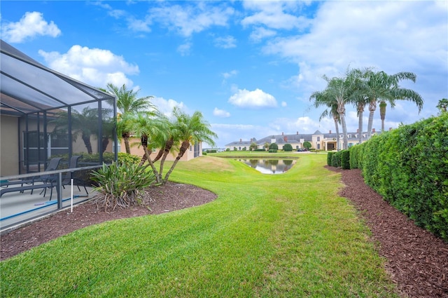 view of yard with glass enclosure and a water view