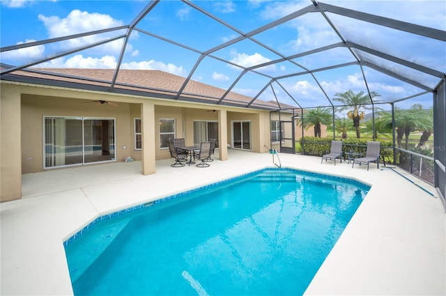 view of pool with ceiling fan, a lanai, and a patio