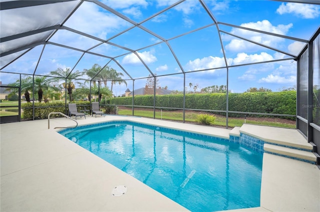 view of swimming pool with pool water feature, a patio area, and a lanai