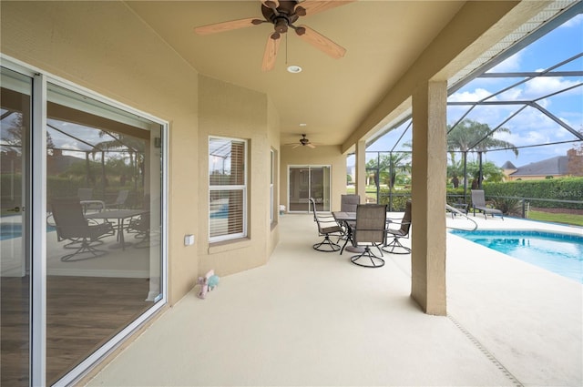 view of patio / terrace featuring a fenced in pool, glass enclosure, and ceiling fan