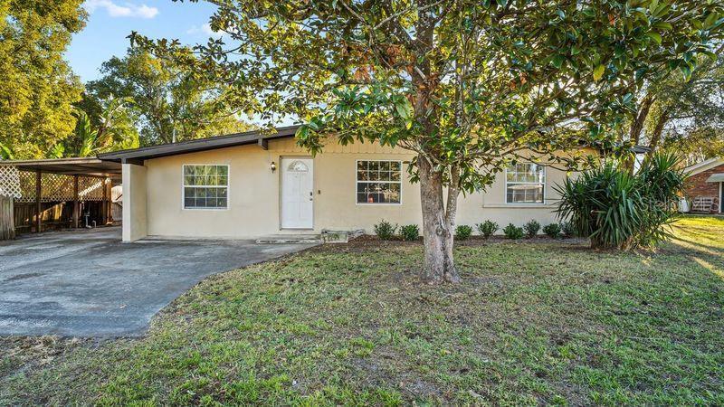 view of front of home with a front yard and a carport