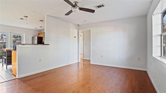 unfurnished living room with french doors, light hardwood / wood-style floors, and ceiling fan