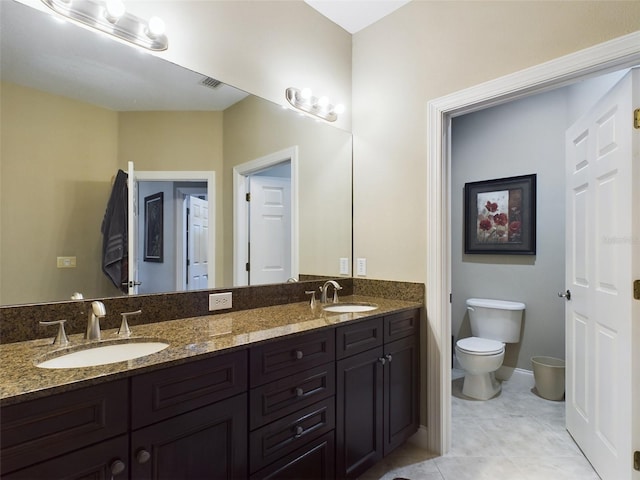 bathroom with tile patterned floors, vanity, and toilet