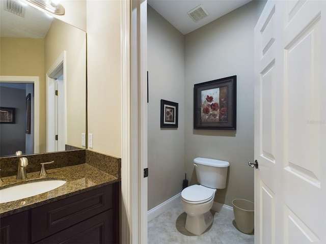 bathroom with tile patterned flooring, vanity, and toilet