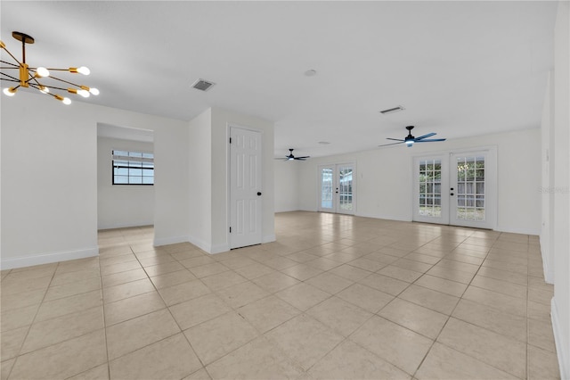 tiled empty room featuring ceiling fan with notable chandelier and french doors