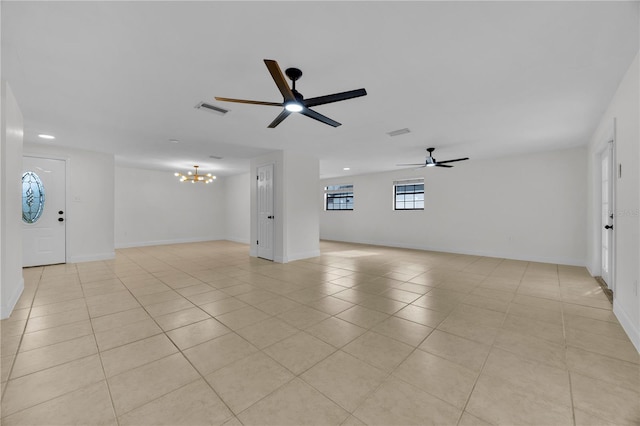 tiled empty room with ceiling fan with notable chandelier