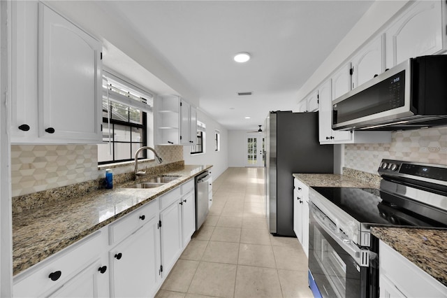 kitchen featuring white cabinets, stainless steel appliances, stone counters, and sink