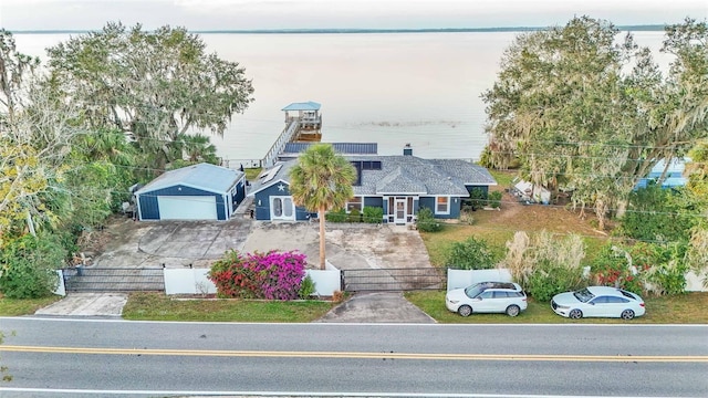 view of front of home with a water view and solar panels