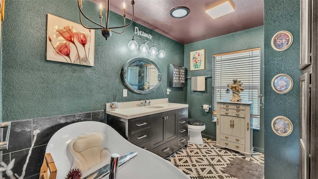 bathroom featuring tile patterned flooring, vanity, a textured ceiling, a tub to relax in, and toilet