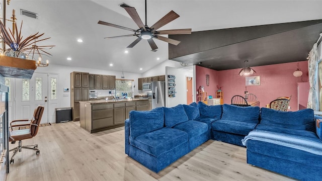 living room featuring ceiling fan, light hardwood / wood-style floors, and vaulted ceiling