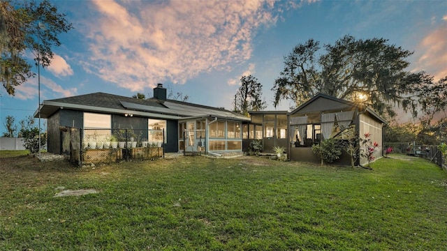 1769 S Lake Reedy Blvd, Frostproof, FL 33843 - rear view of house with a sunroom, roof mounted solar panels, and a chimney
