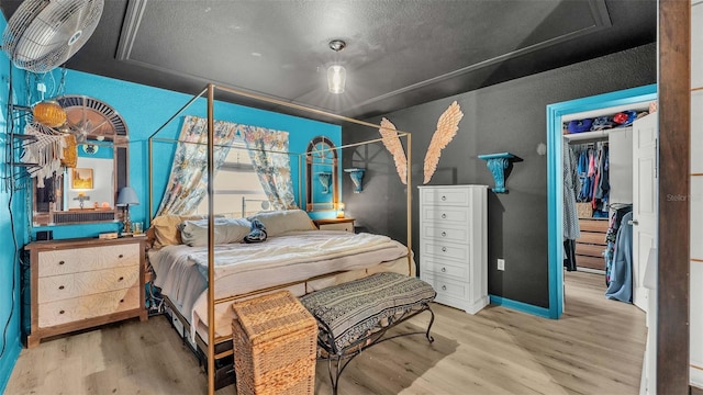 bedroom with wood-type flooring, a closet, and a textured ceiling