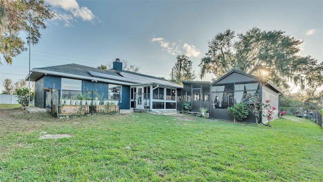 1769 S Lake Reedy Blvd, Frostproof, FL 33843 - rear view of property with a sunroom, roof mounted solar panels, and a chimney