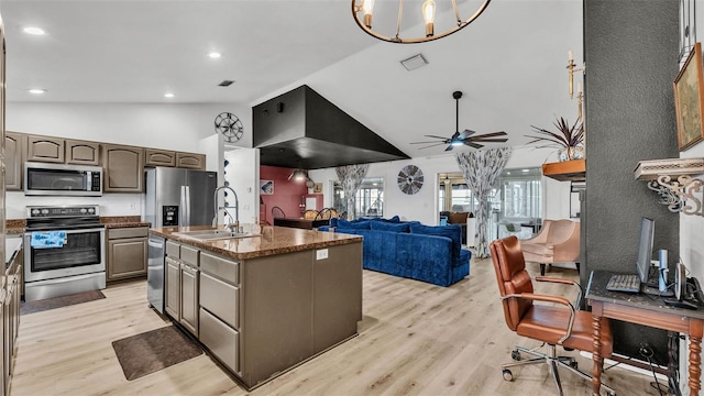 kitchen with sink, light wood-type flooring, appliances with stainless steel finishes, an island with sink, and ceiling fan with notable chandelier