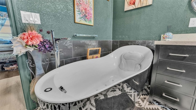 1769 S Lake Reedy Blvd, Frostproof, FL 33843 - full bath featuring a freestanding bath, tile walls, a textured wall, and wood finished floors