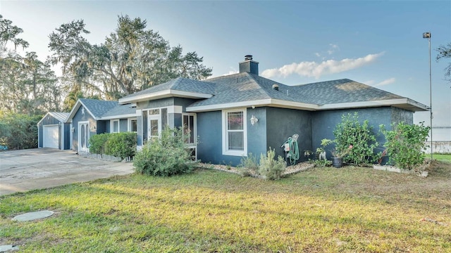 1769 S Lake Reedy Blvd, Frostproof, FL 33843 - view of front of home featuring stucco siding, a chimney, a shingled roof, a front lawn, and a detached garage